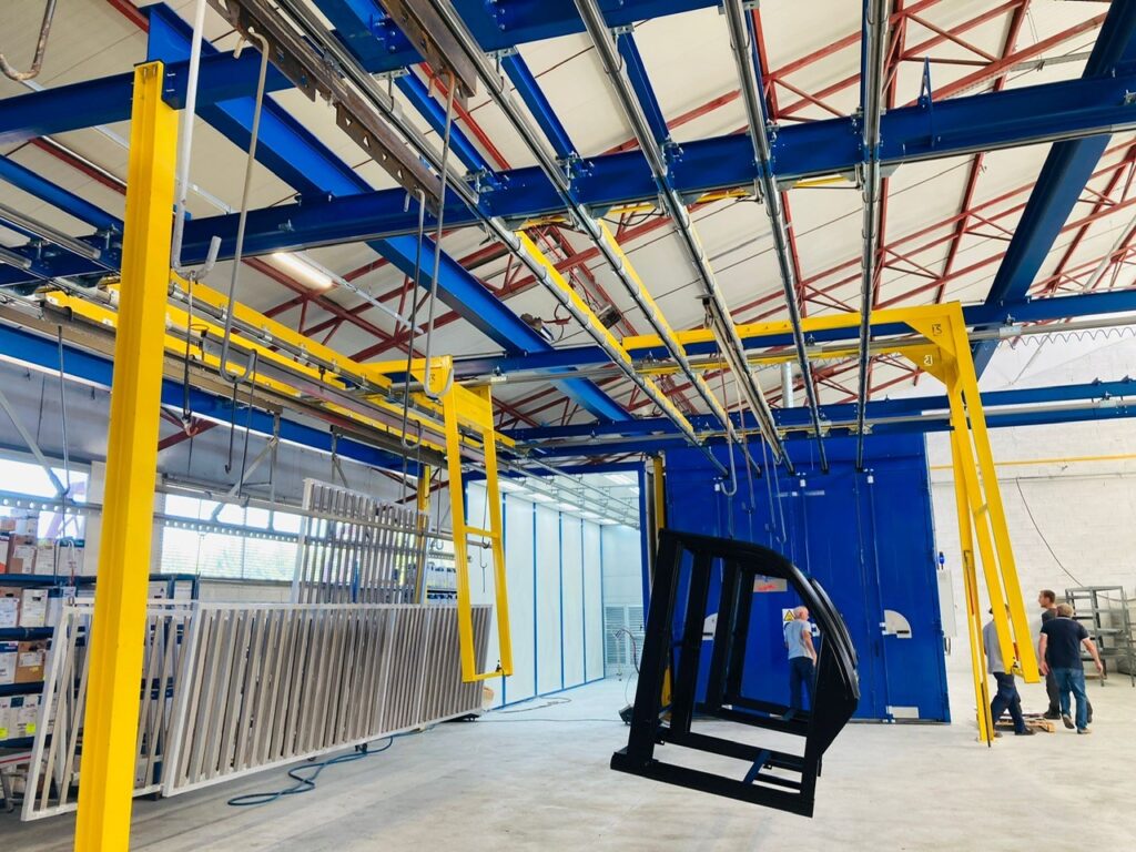 Structure de convoyage aérien monorail installée en hauteur dans un atelier